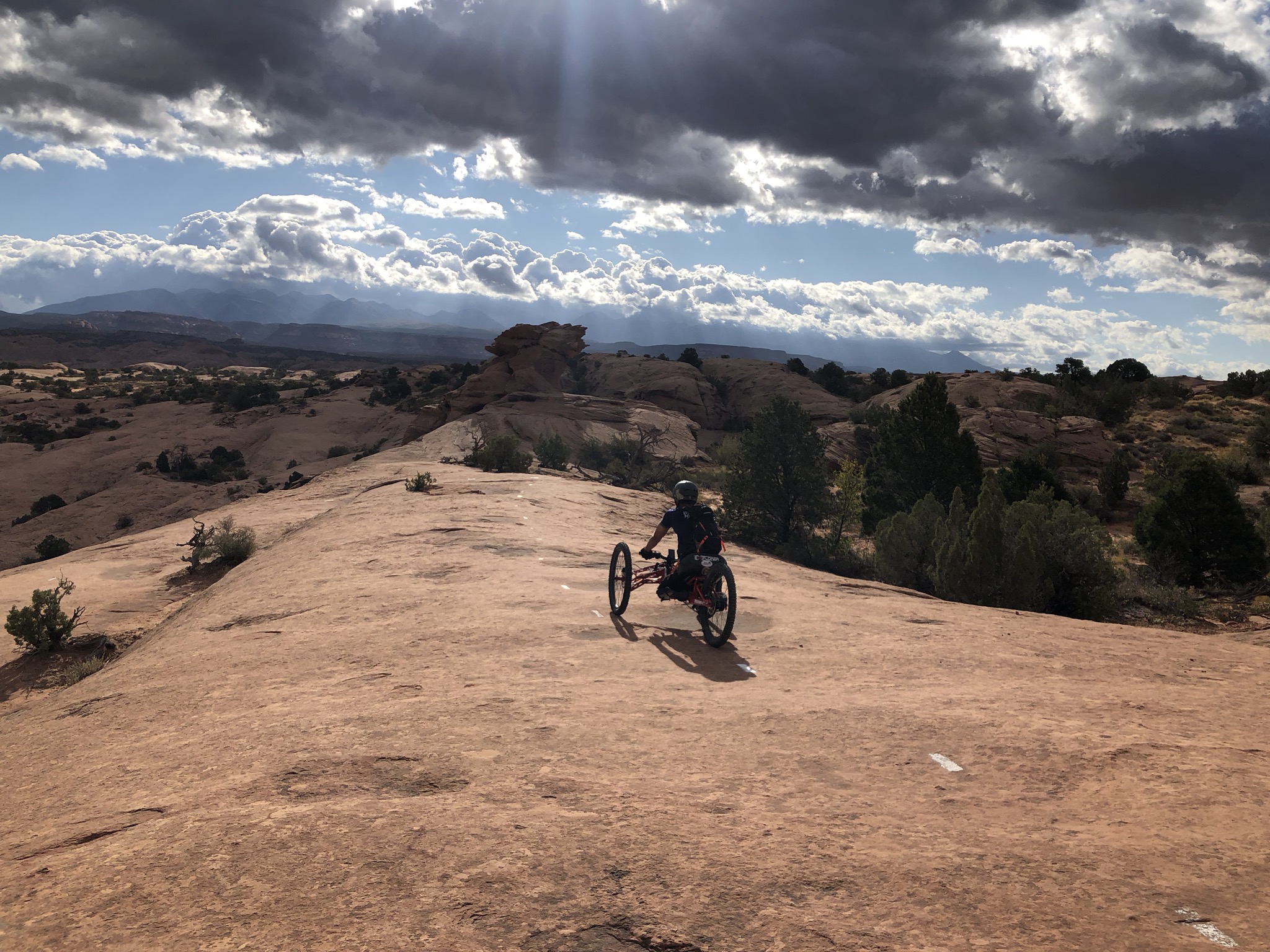 Image of man on hand pedal bike on red rocks